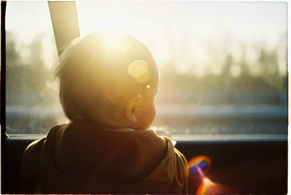 Baby looking through car window. Photo by Anastasia Shuraeva.
